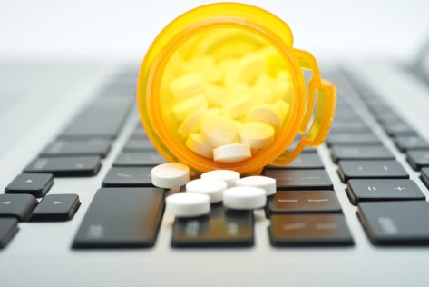 Online prescription order concept with bottles of medicine on keyboard